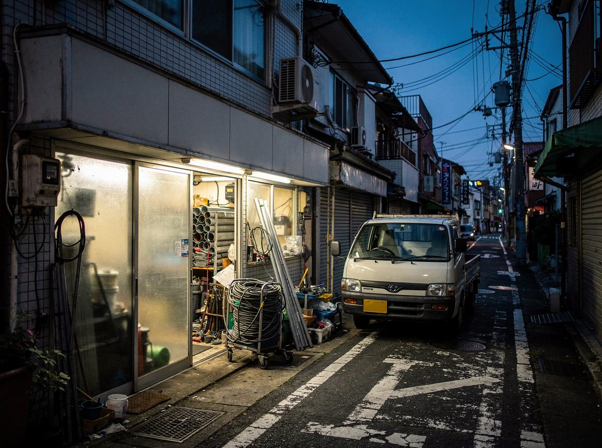 夕方に灯りがついた普請堂の工房の外観